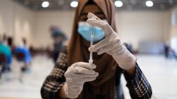 A healthcare worker prepares a dose of the Pfizer-BioNTech Covid-19 booster shot at a vaccine clinic inside Trinity Evangelic Lutheran Church in Lansdale, Pennsylvania, U.S, on Tuesday, Apr. 5, 2022. 