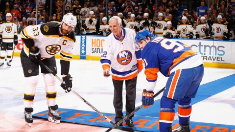 Bossy drops the puck in front of Zdeno Chara of the Boston Bruins and John Tavares of the New York Islanders prior to the game during Mike Bossy tribute night at the Nassau Veterans Memorial Coliseum on January 29, 2015 in Uniondale, New York.