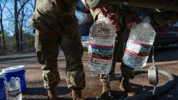 National Guard sergeants fill gallons for a resident at a public water distribution site after a recent bout of cold weather caused large numbers of water outages, some going into their third week, in Jackson, Mississippi, U.S. March 4, 2021.  REUTERS/Rory Doyle