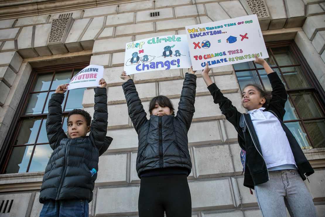 Youngsters hold up placards during a 2019 climate change protest at Parliament Square in London.