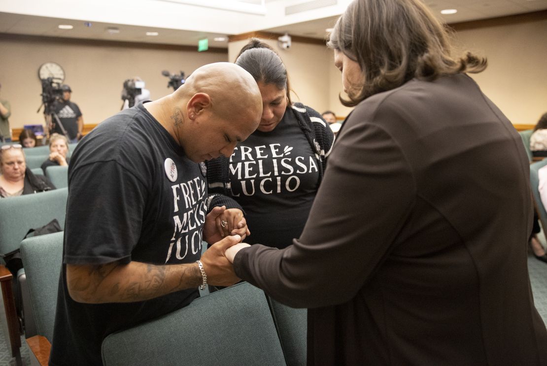 John Lucio, left, prays with his wife, Michelle Lucio, center, and Jennifer Allmon, executive director of the Texas Catholic Conference of Bishops, before a hearing about his mother by the Interim Study Committee on Criminal Justice Reform.