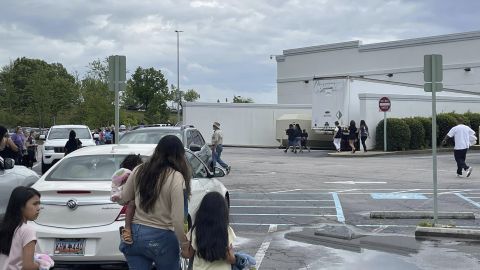 People walk through a parking lot at the Columbiana Centre mall in Columbia, S.C. on Saturday, April 16, 2022, as police investigate a shooting at the mall.
