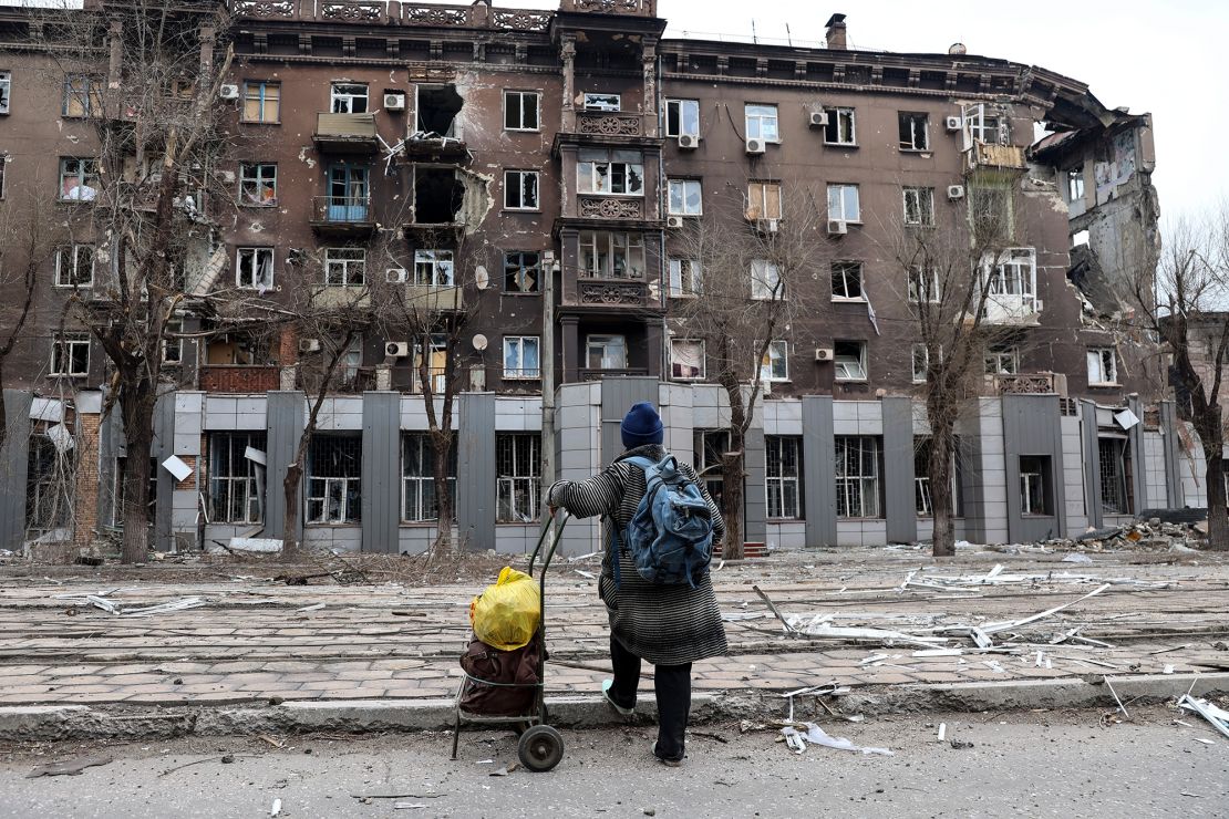A local resident looks at a damaged apartment building near the Illich metallurgical plant in Mariupol on Saturday, April 16, 2022. 