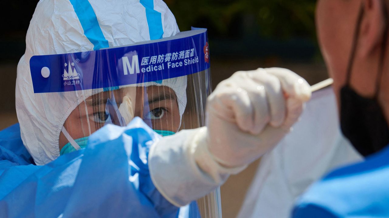 A health worker wearing personal protective equipment conducts a swab test for the Covid-19 coronavirus in a compound during a Covid-19 lockdown in Pudong district in Shanghai on April 17, 2022. - China OUT 