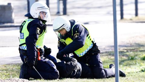 Police arrest a protester during rioting in Norrköping.