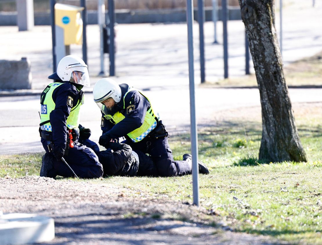 Police arrest a protester during rioting in Norrköping.