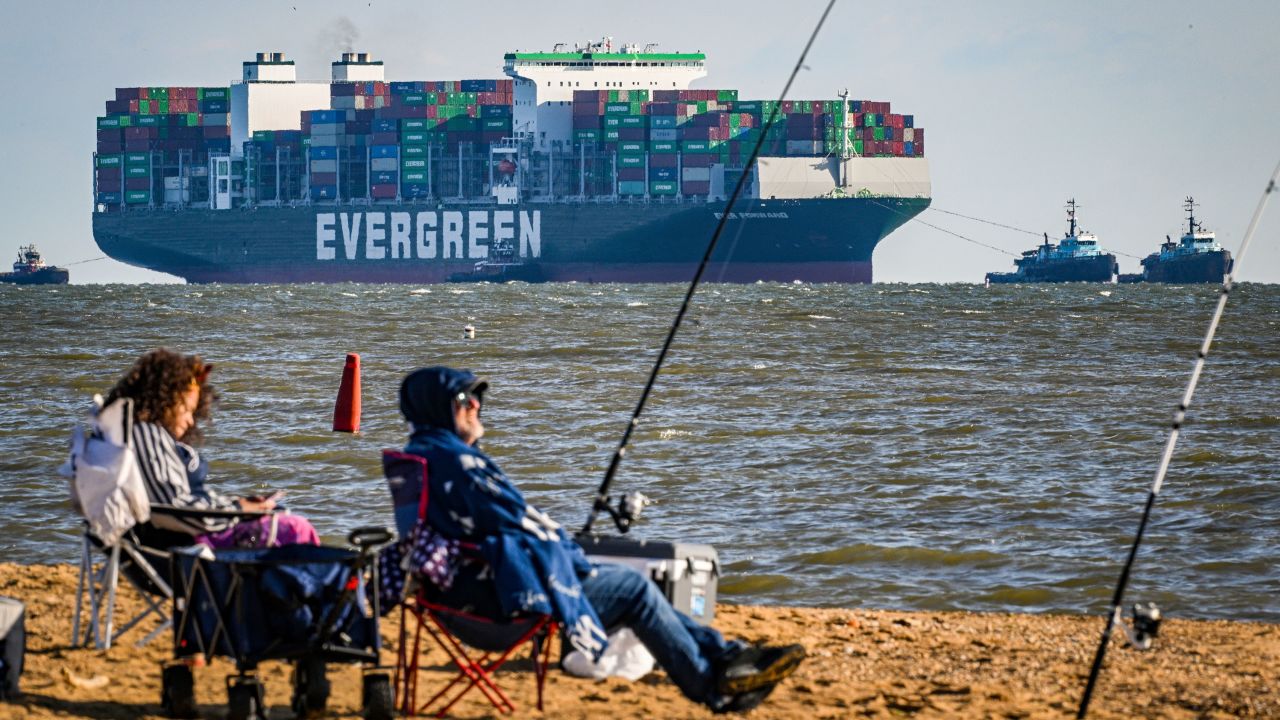 Michelle Micheals, left, of Bowie, and Robert Fenstermacher, of District Heights, fish as the Ever Forward approaches the Chesapeake Bay Bridge in Sandy Point, Md. The ship was pulled from mud outside the shipping channel off Pasadena, Maryland, where is has spent the past month aground.