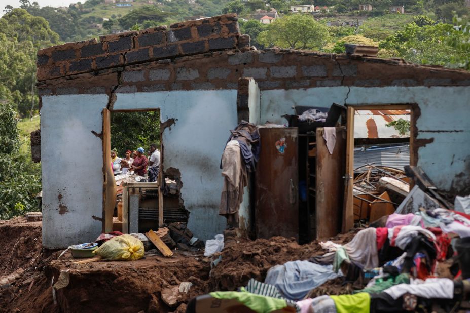 People stand next to the remains of a house in the Kwandengezi township on April 15.