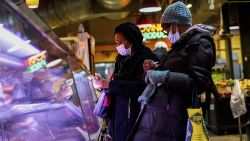 FILE - Customers wear face masks to protect against the spread of the coronavirus as they shop at the Reading Terminal Market in Philadelphia, Feb. 16, 2022.  COVID cases are starting to rise again in the United States, with numbers up in most states and up steeply in several. One expert says he expects more of a "bump" than the monstrous surge of the first omicron wave, but another says it's unclear how high the curve will rise and it may be more like a hill. (AP Photo/Matt Rourke, File)