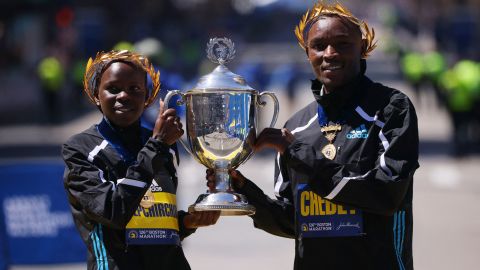Kenya's Evans Chebet (R) and Peres Jepchirchir (L) celebrate with the Boston Marathon trophy after winning the elite men's and women's races.