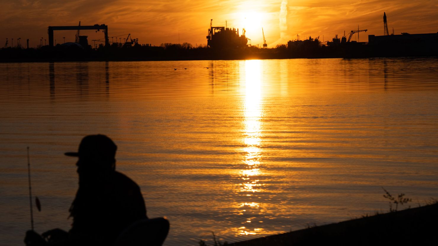 The sun sets behind a fossil fuel complex on the Mobile River in Alabama.