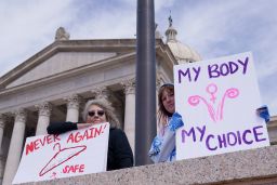 Dani Thayer, left, and Marina Lanae, both of Tulsa, Oklahoma, protest at the state Capitol, Wednesday, April 13, 2022, in Oklahoma City.