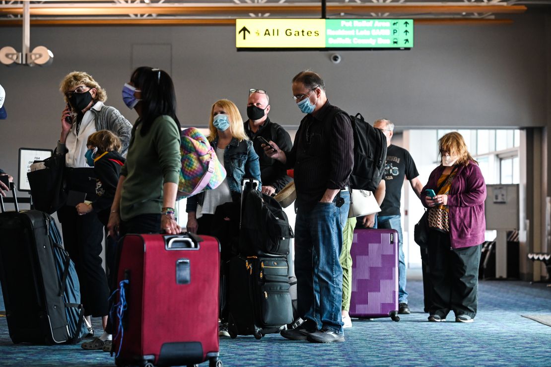 Passengers with face masks wait in line in March 2021 at a ticket booth in the main terminal at Long Island MacArthur Airport in Ronkonkoma, New York.