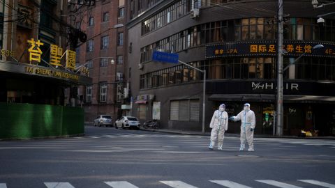 Workers in hazmat suits keep watch on a street during Shanghai's lockdown on April 16.