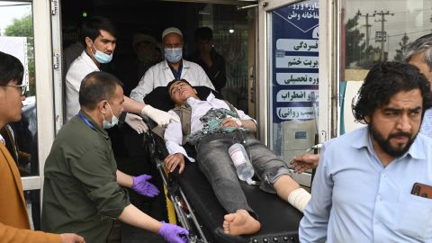 Medical staff move a wounded youth after explosions rocked a school in Kabul on Tuesday.