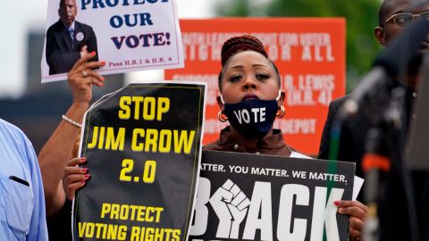 A person holds up signs during a voting rights rally at Liberty Plaza near the Georgia State Capitol on Tuesday, June 8, 2021, in Atlanta.