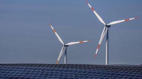 Wind turbines turn behind a solar farm in Rapshagen, Germany, October 2021. 