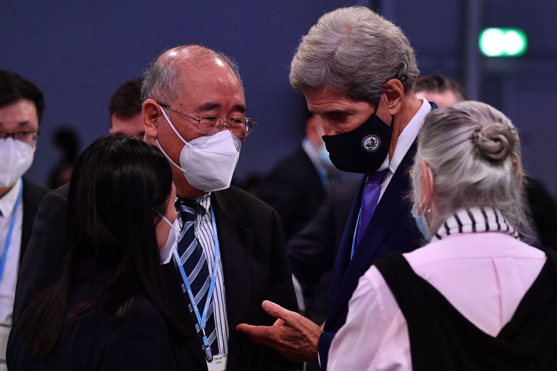 Kerry leans in to speak with China's special climate envoy Xie Zhenhua at the COP26 climate summit in Glasgow in November.