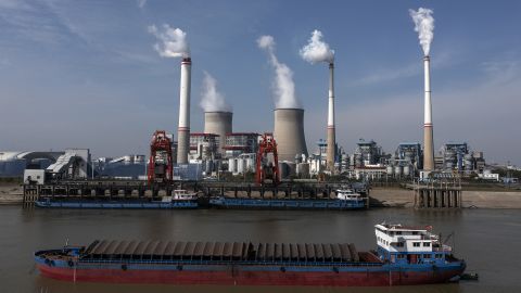 Statki przewożą węgiel przed elektrownią węglową w Hanchuan, prowincja Hubei, Chiny, listopad 2021 r.