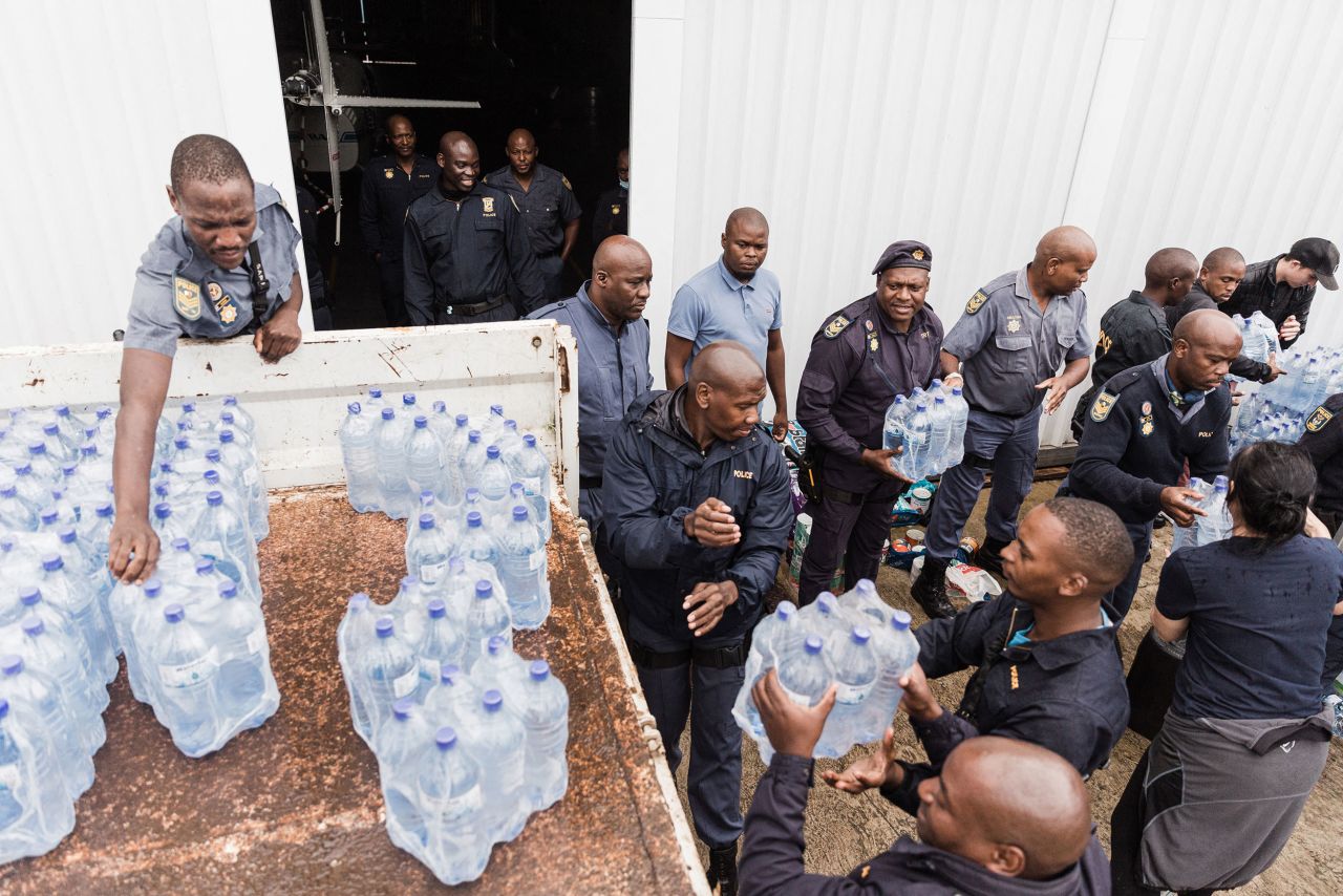 Volunteers and law enforcement workers pack water supplies at a search-and-rescue center in Durban on April 18.