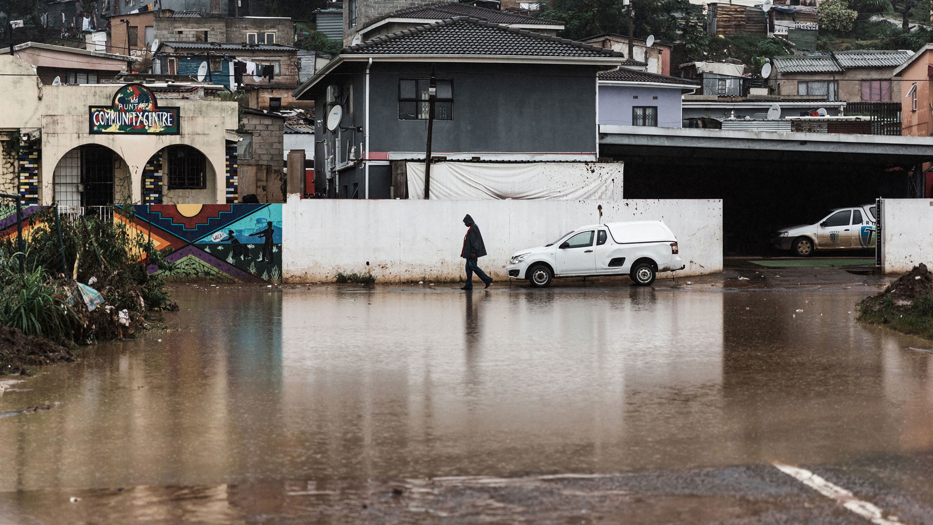 A person walks past flooding in Clare Estate outside of Durban, South Africa, on Monday, April 18.