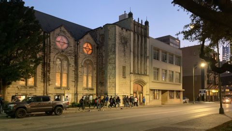 Every evening, migrants walk from Travis Park to Travis Park Church for overnight shelter. Pastor Gavin Rogers opened the shelter in the church's basement after migrants started sleeping outside in the park.