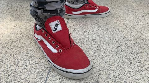 Migrants give up the laces of their shoes during US immigration processing.