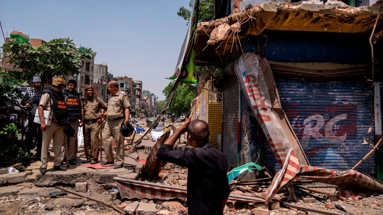 Policemen stand next to a partially demolished shop in the area that saw communal violence during a Hindu religious procession on Saturday, in New Delhi's northwest Jahangirpuri neighborhood, in New Delhi, India, Wednesday, April 20, 2022. 
