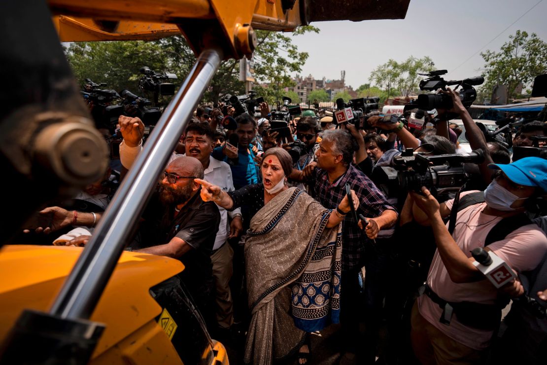 Communist Party of India leader Brinda Karat, center, stands in front of a bulldozer during the demolition of Muslim-owned shops in New Delhi's northwest Jahangirpuri neighborhood, in New Delhi, India, Wednesday, April 20, 2022. 