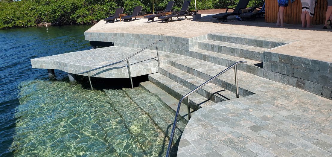 Green quartz-tiled stairs descend into the waters below. 