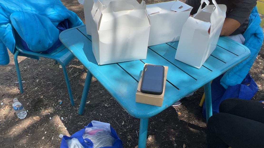 A government-issued cell phone sits on a table in a park where recently released migrants have been gathering in San Antonio, Texas.