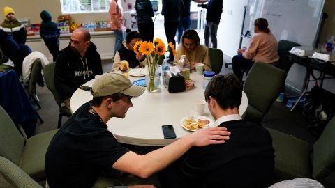 Volunteer Silas Breen prays at Calvary San Diego on April 1 with David, a Ukrainian man. Pastor Phil Metzger says the Ukrainians' arrival has been "life-changing" for his community.