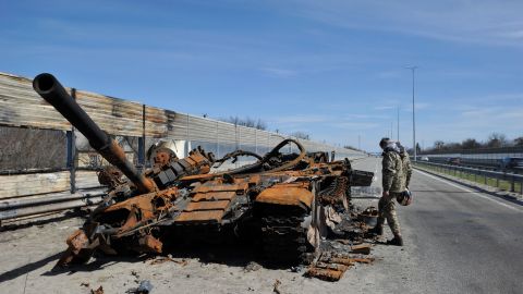 A man inspects destroyed tank of the Russian army about 40 kilometers west of Kyiv, the Ukraine capital. 