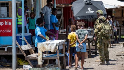 Australian Army soldiers talk with locals during a community engagement patrol through Honiara on November 27, 2021.