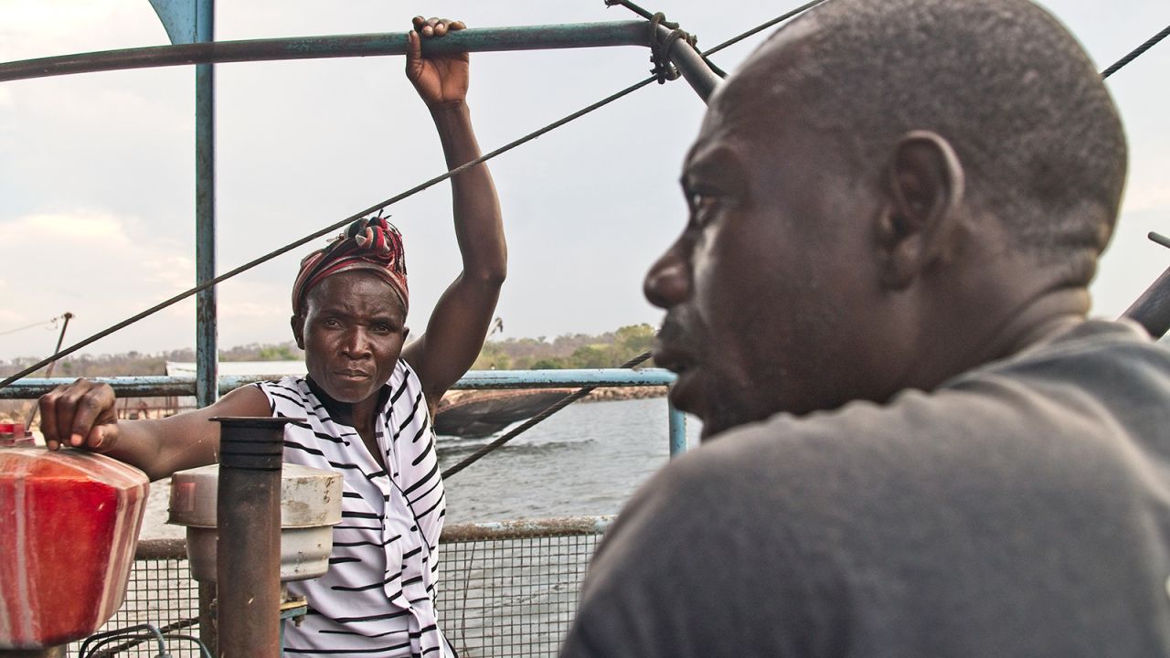 Brandina Mudimba looks on as the boat captain lists the remaining items required to repair their broken down fishing rig docked for months at Chilala Fishing Camp on 01 November 2021 in Binga district, Matabeleland North Province of Zimbabwe.