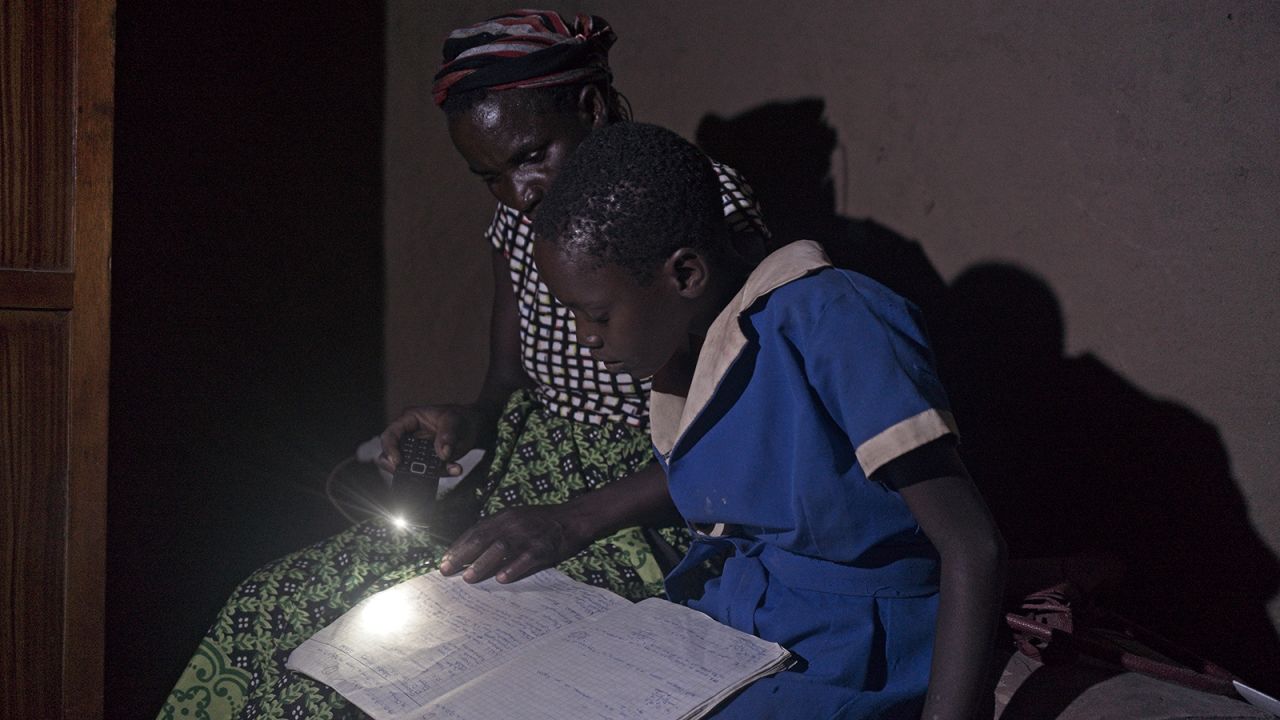 Brandina helping her daughter with homework after school at her homestead in Simatelele village on 02, November 2021. When the rig was working she could pay school fees and buy uniforms with less difficulties.