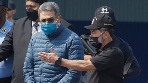 Former Honduran president Juan Orlando Hernández, center, is taken in handcuffs to a waiting aircraft as he is extradited to the United States.