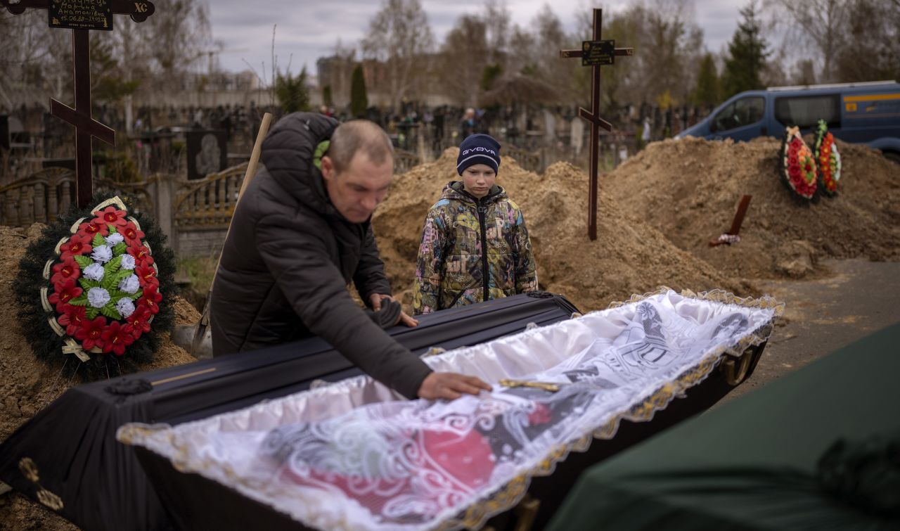 Vova, 10, looks at the body of his mother, Maryna, lying in a coffin as his father, Ivan, prays during her funeral in Bucha on April 20. She died during Russia's occupation of the city, as the family sheltered in a cold basement for more than a month.  Zelensky says Russia waging war so Putin can stay in power &#8216;until the end of his life&#8217; 220421144953 06 ukr gallery update 042122