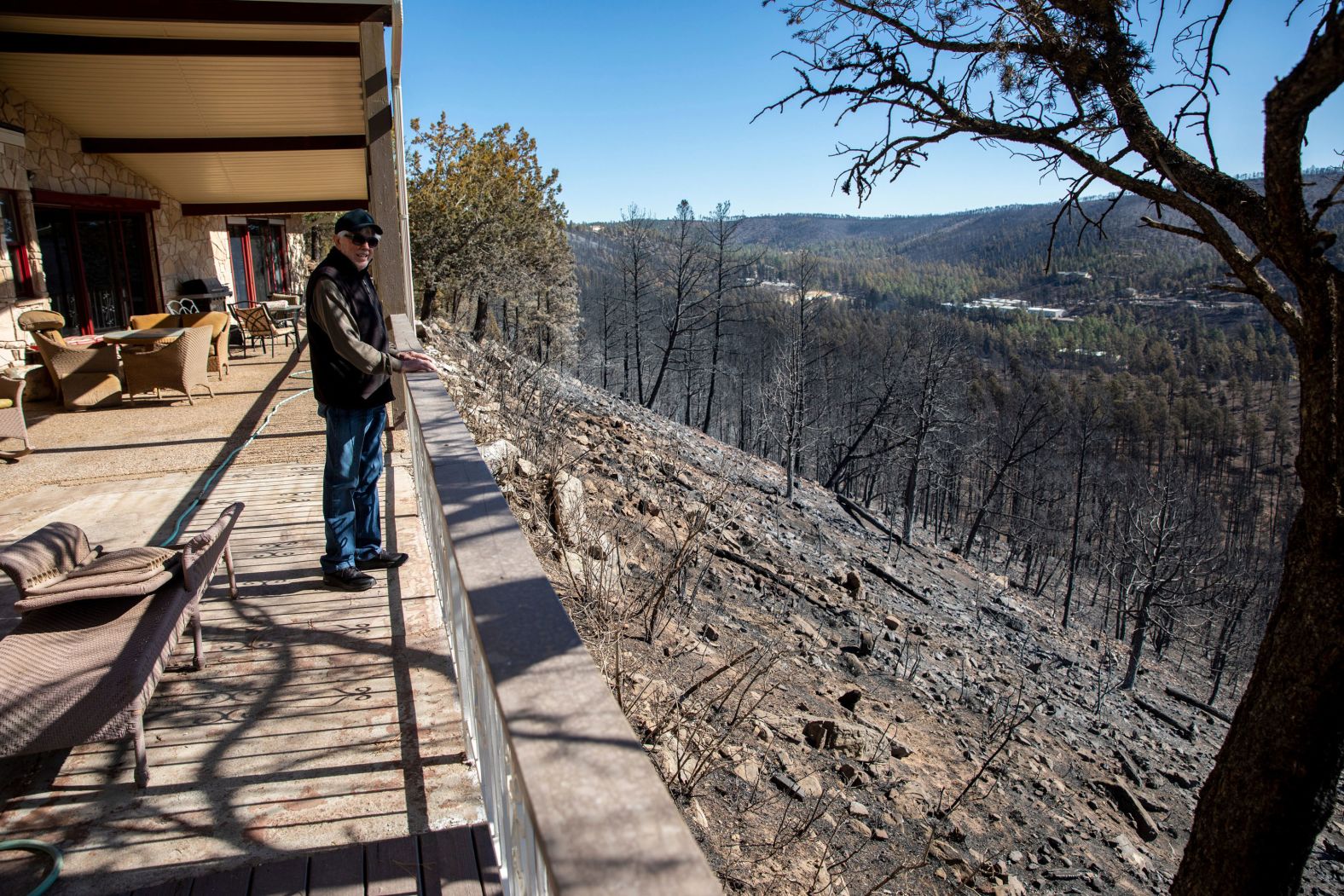 Ron Romack stands on his patio on Friday, April 15, overlooking an area that was burned by the <a href="index.php?page=&url=https%3A%2F%2Fwww.cnn.com%2F2022%2F04%2F14%2Fweather%2Fnew-mexico-wildfires-thursday%2Findex.html" target="_blank">McBride Fire</a> in Ruidoso, New Mexico. The 82-year-old said he and his son protected their home with a couple of water hoses until they got help from the local fire department a few hours later.