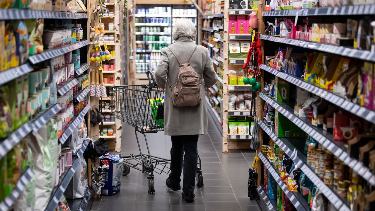 A woman walks through a supermarket with her shopping cart on March 31, 2022, in Neubiberg, Bavaria.