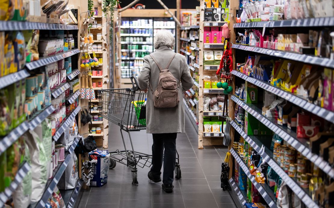 A woman walks through a supermarket with her shopping cart on March 31, 2022, in Neubiberg, Bavaria.