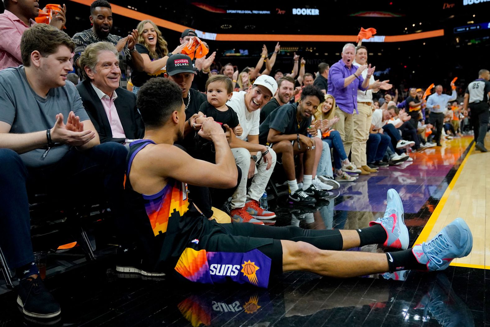 Phoenix guard Devin Booker <a href="index.php?page=&url=https%3A%2F%2Fbleacherreport.com%2Fvideos%2F239634-devin-booker-fist-bumps-baby" target="_blank" target="_blank">fist-bumps a young child</a> after making a shot and falling out of bounds during an NBA playoff game on Tuesday, April 17.