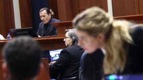 Amber Heard speaks to her legal team as Johhny Depp is on the stand in their defamation trial.