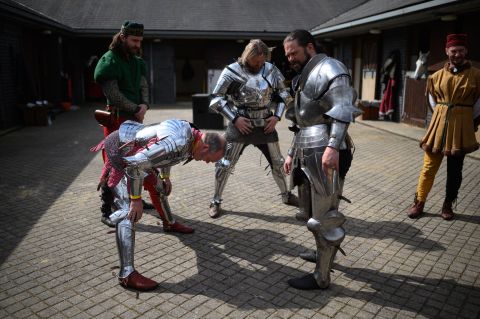 Men dressed as knights stretch as they prepare to take part in the International Jousting Tournament in Leeds, England, on Monday, April 18.