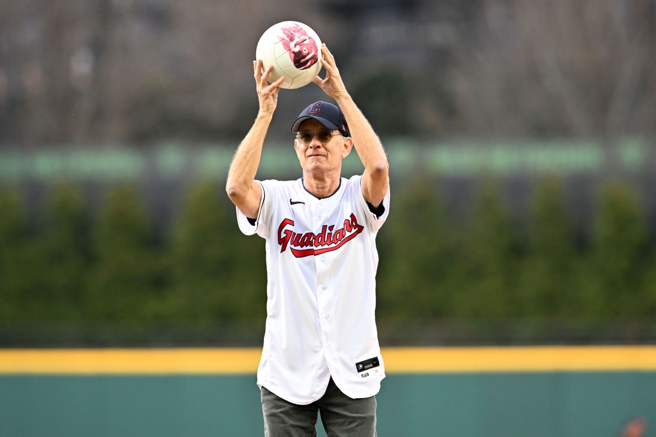 Actor Tom Hanks holds Wilson, the famous volleyball from his 2000 movie "Cast Away," as he throws out the ceremonial first pitch at a Cleveland Guardians baseball game on Friday, April 15.