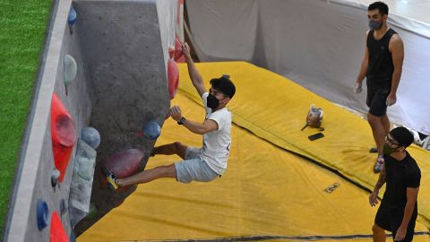 Bouldering is performed without ropes. Here, a man practices at a Jakarta, Indonesia, mall.