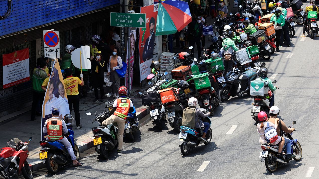 Delivery bikers line up at a mango sticky rice shop in Bangkok on April 21, 2022.