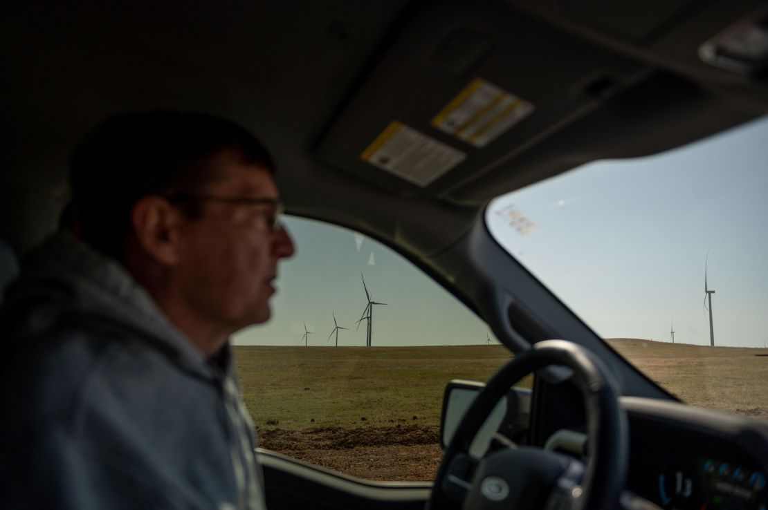 Wind turbines are seen in the distance from Scott Hampton's truck as he drives on a county road in Weatherford.