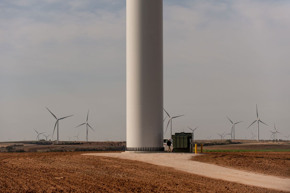 A worker walks along the base of a wind turbine at the Traverse wind farm.