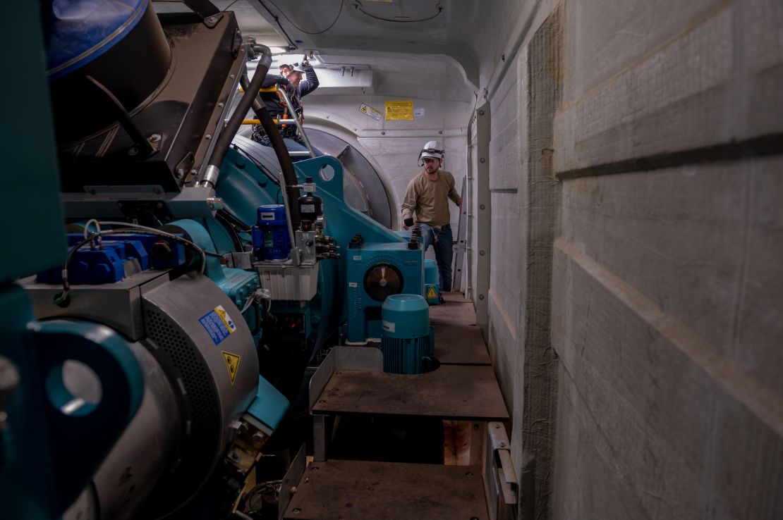 Blake Panek, senior wind technician, performs a routine inspection inside one of the wind turbines at the Traverse wind farm. To his left is Matt Miller, environmental coordinator principal at Traverse.